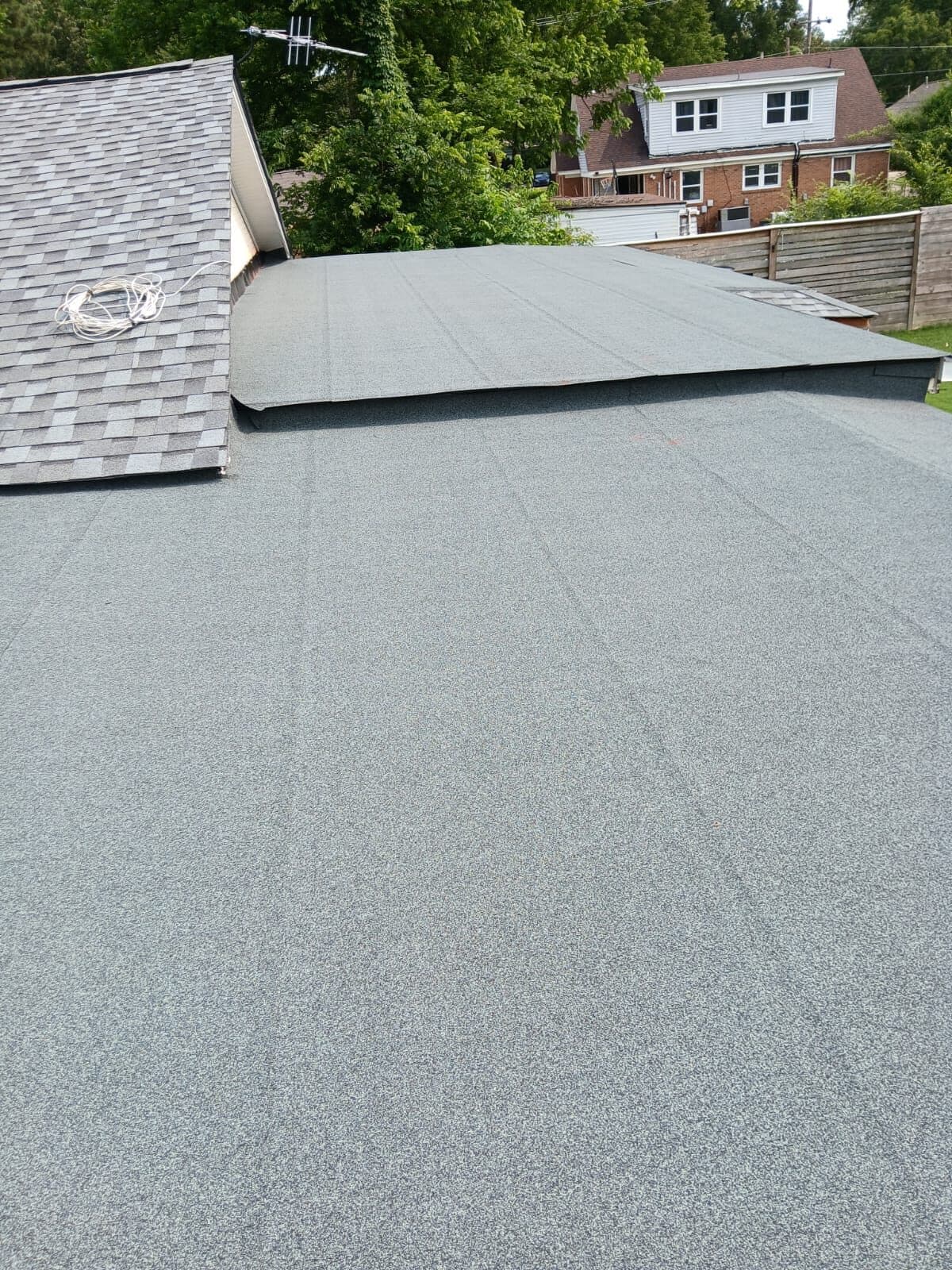 Gray granulated low-slope roofing on a residential addition