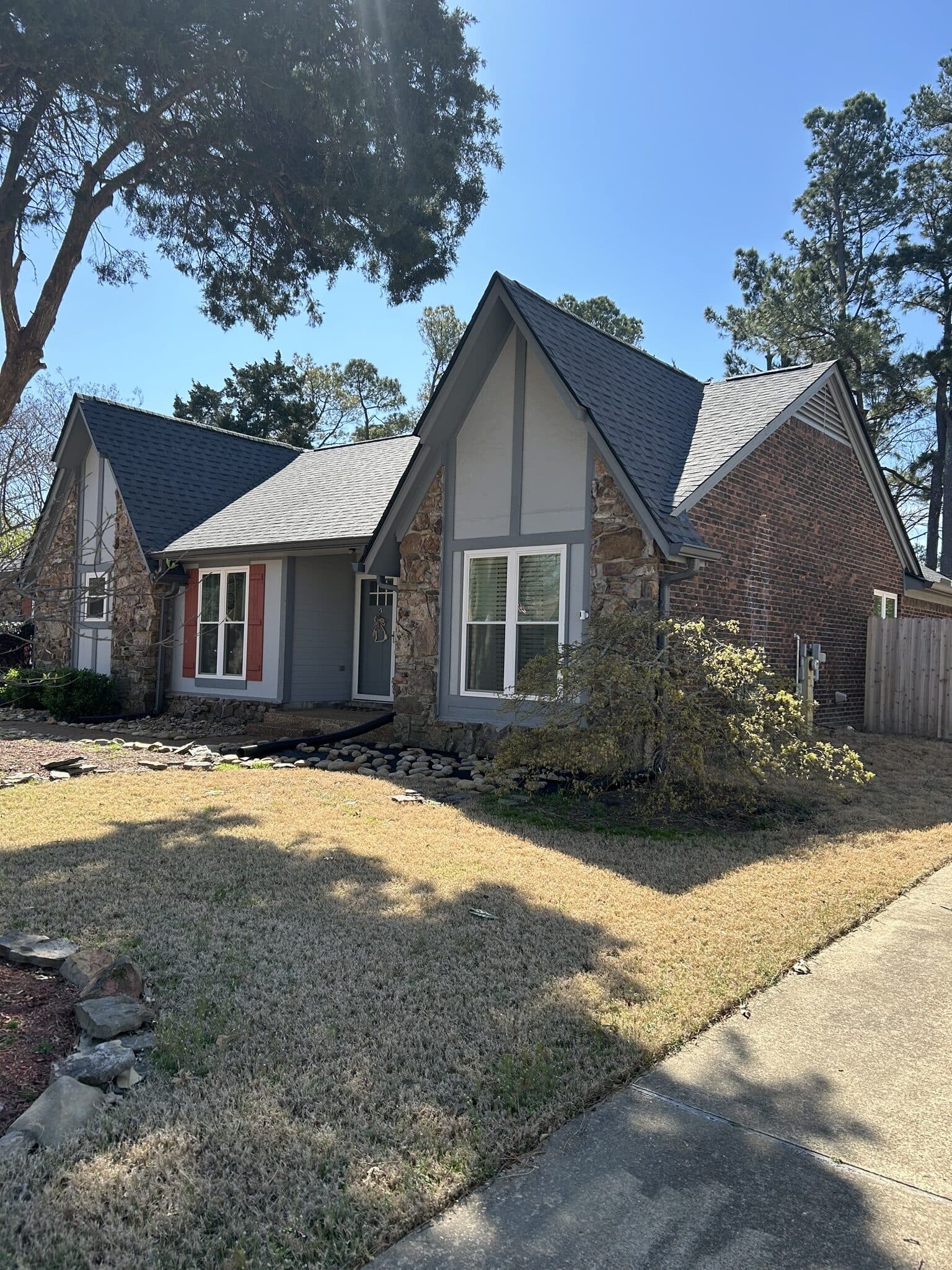 Steep gabled brick home with landscaped front yard and new roof