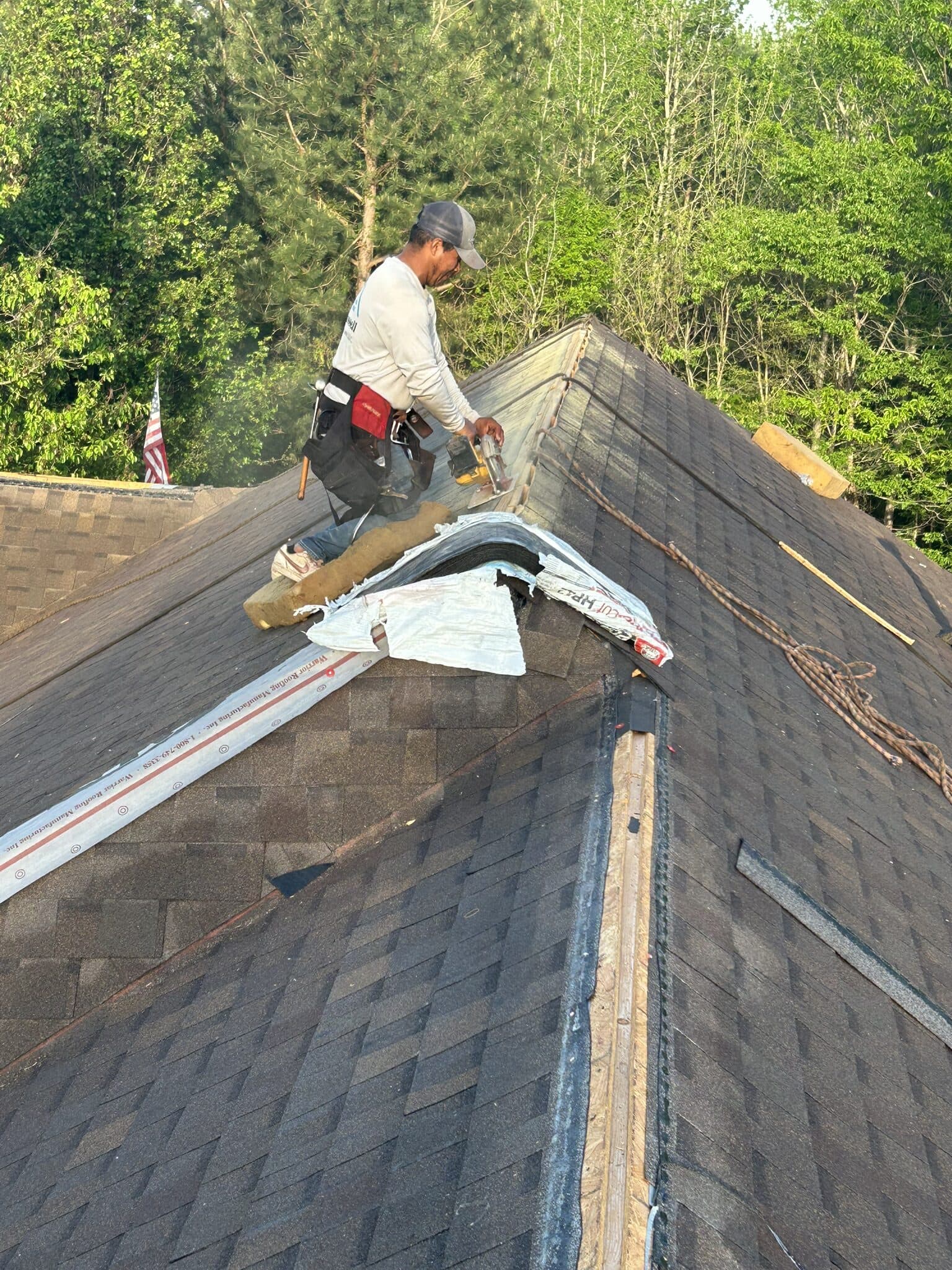 Crew member working at the ridge of a steep slope during tear-off
